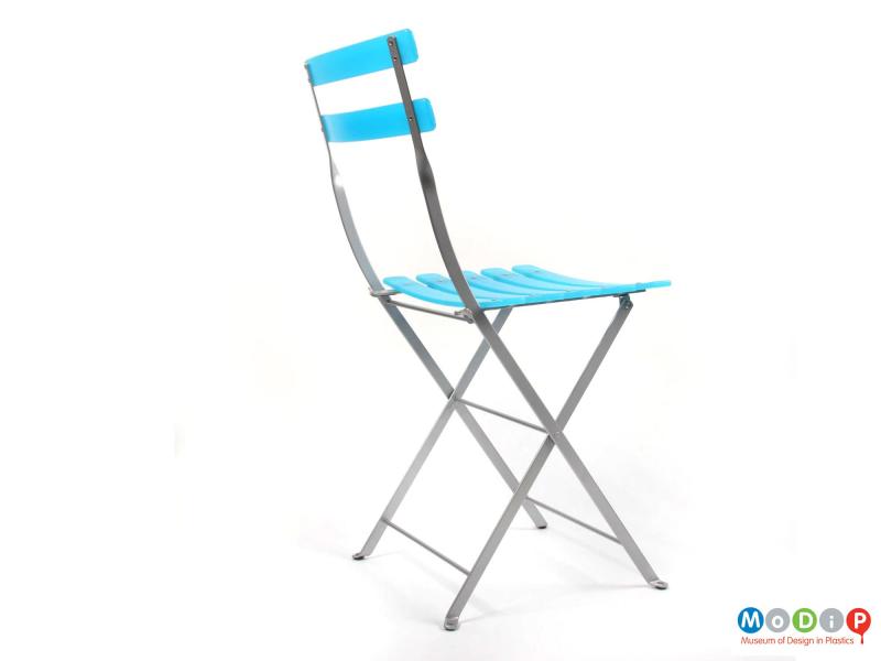 Rear side view of an Habitat folding chair showing the two back slats and the metal frame.