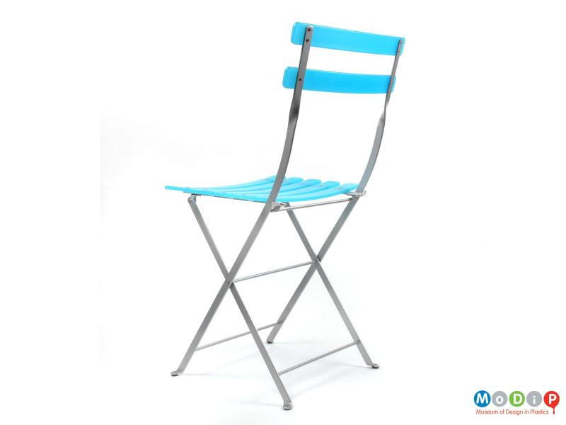 Rear side view of an Habitat folding chair showing the two back slats and the metal frame.