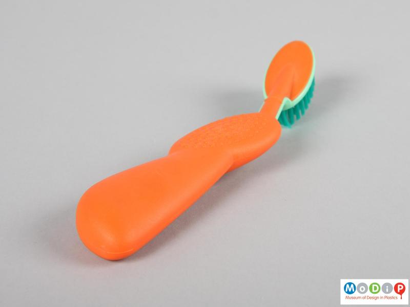 Side view of a toothbrush showing the large handle and moulded grip.