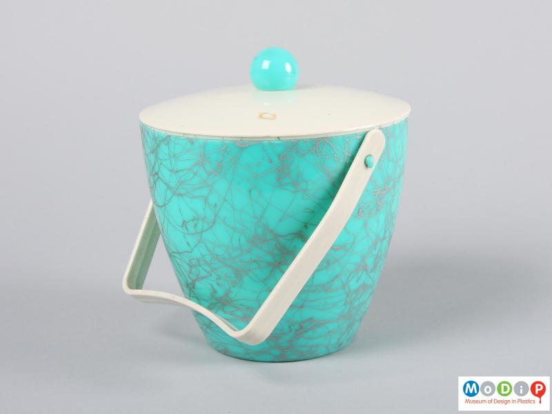 Side view of an ice bucket showing the handle.