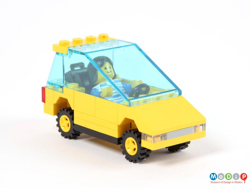Side view of a toy car showing the figure in the driver's seat.