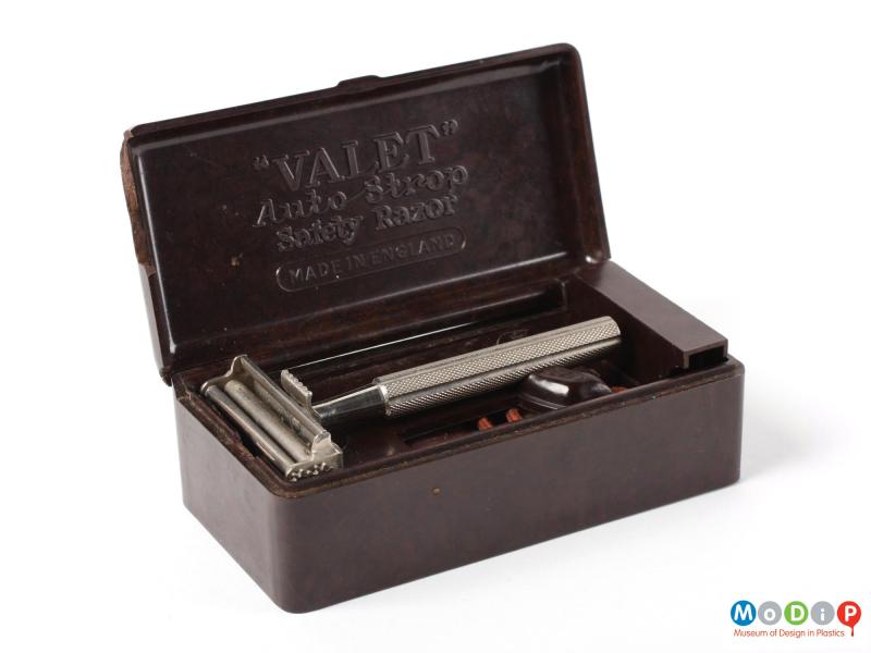 Front view of a Valet safety razor box with its lid open and showing the safety razor, the spare blade holder in the base and the moulded inscription in the lid.