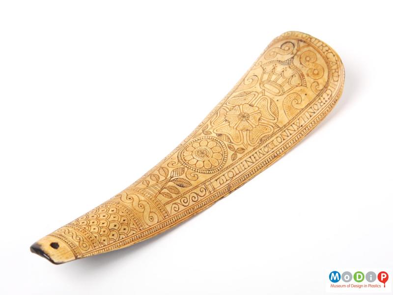 Front view of a shoe horn showing the elaborate engraving.