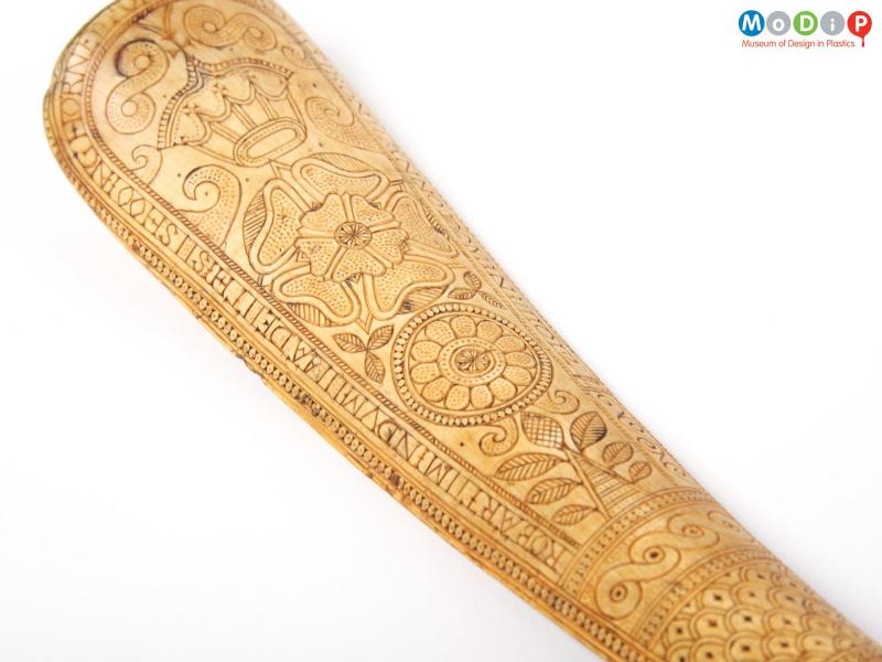 Close view of a shoe horn showing the carving.