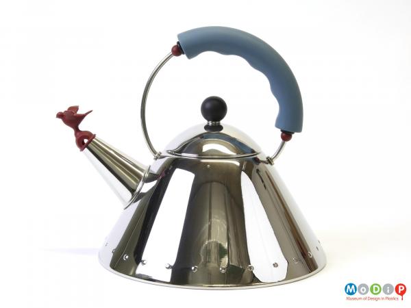 Side view of a kettle showing the trimmed handle and bird shaped whistle.