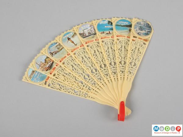 Front view of a hand fan showing the glued-on pictures.