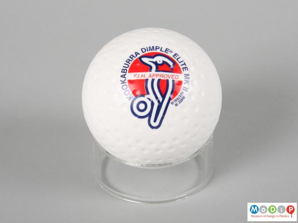 Side view of a hockey ball showing the printed logo and information.