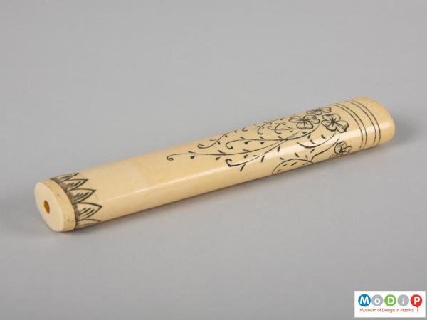 Side view of a toothbrush cover showing the inscribed decoration.