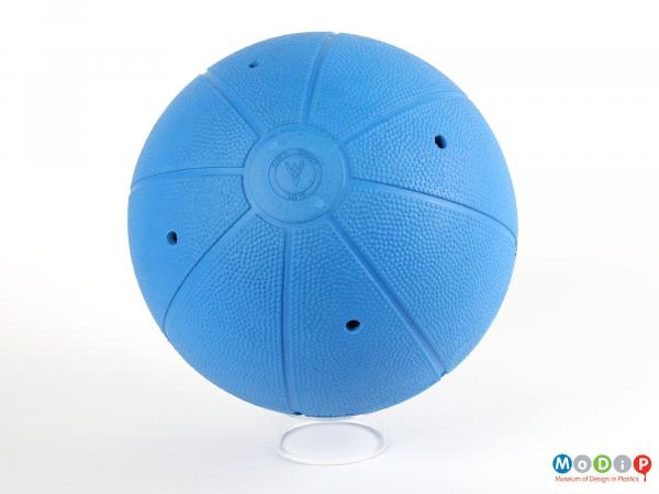Side view of a goalbball showing the surface texture and the holes revealing the bell compartments.