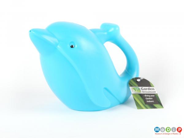 Side view of a watering can showing the tail forming the handle.