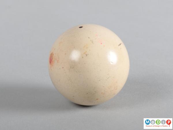 Side view of a billiard ball showing the pitted surface.