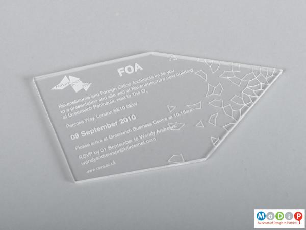 Front view of an invitation showing the asymmetric shape and etched details.