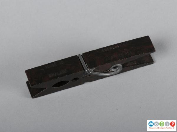 Side view of a clothes peg showing the moulded inscription.