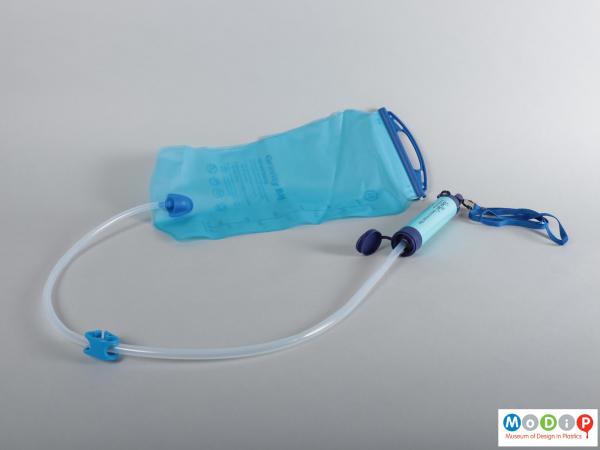 Side view of a drinking water system showing the bag, tube, and straw together.