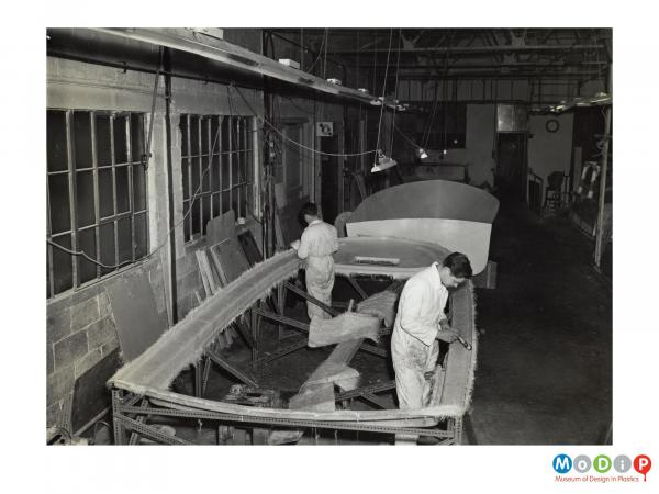 Scanned image showing a small boat being built.