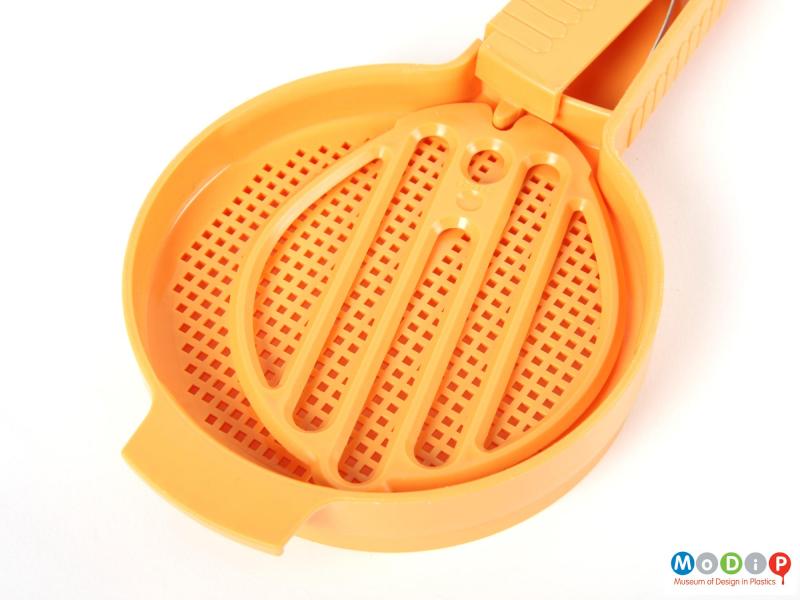 Top view of a Tupperware sifter showing the moving plate and sifting holes.