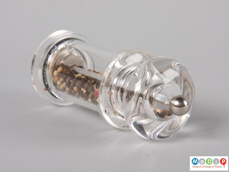 Top view of a 505 pepper grinder on its side to expose the top of the metal knob and clear top section.