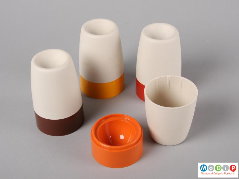 Top view of four Tupperware egg cups showing one cup with the cover removed.  The base shows a ridge fo the cover to sit on whilst the inside of the cover has gripping ribs.