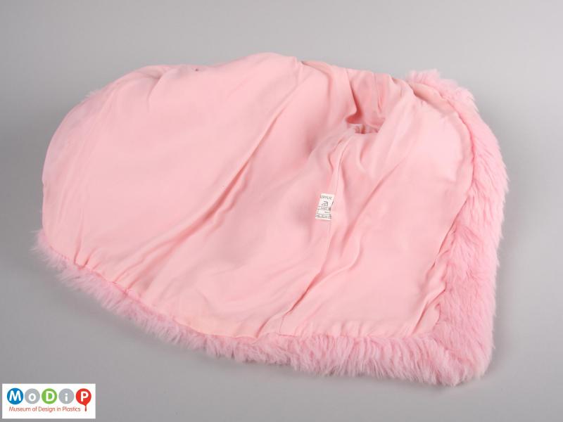 Inside view of a pink hooded coat showing the smooth lining.