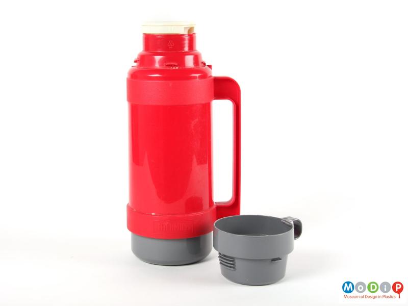 Side view of a Thermos flask showing the cup removed to expose the internal cover.