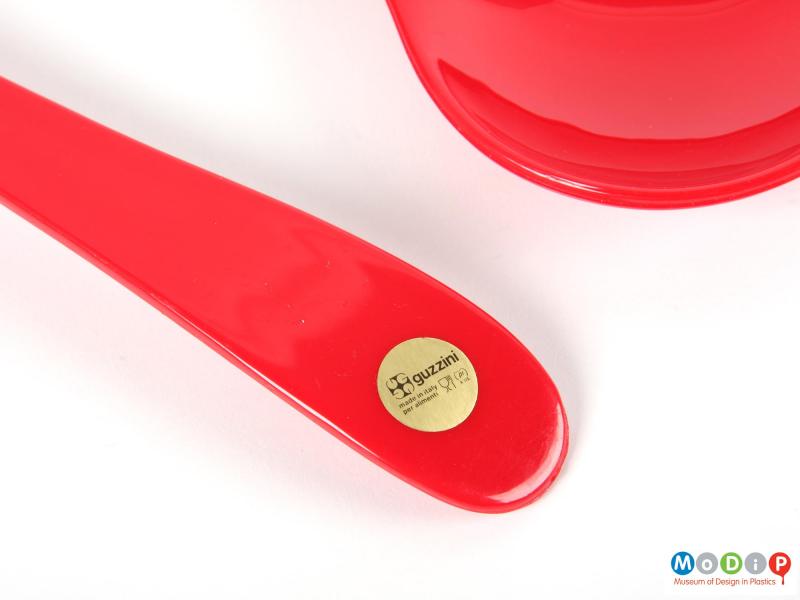 Close view of a set of Guzzini salad servers showing the adhesive lable on one of the handles.