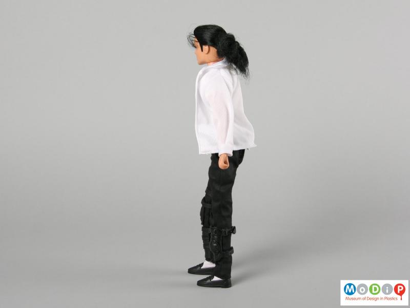Side view of a Michael Jackson doll showing the black hair held back in a pony tail.