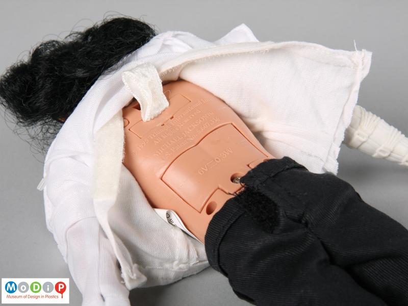 Close view of a Michael Jackson doll showing the back of the doll with the moulded inscriptions and electronics covers.
