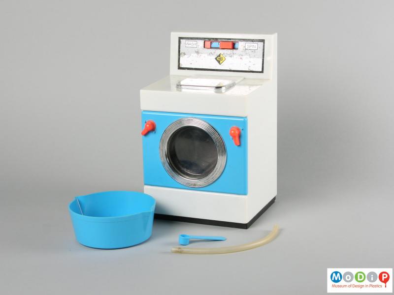 Front view of a Casdon toy washing machine showing the washing machine, measure, bowl and tube.