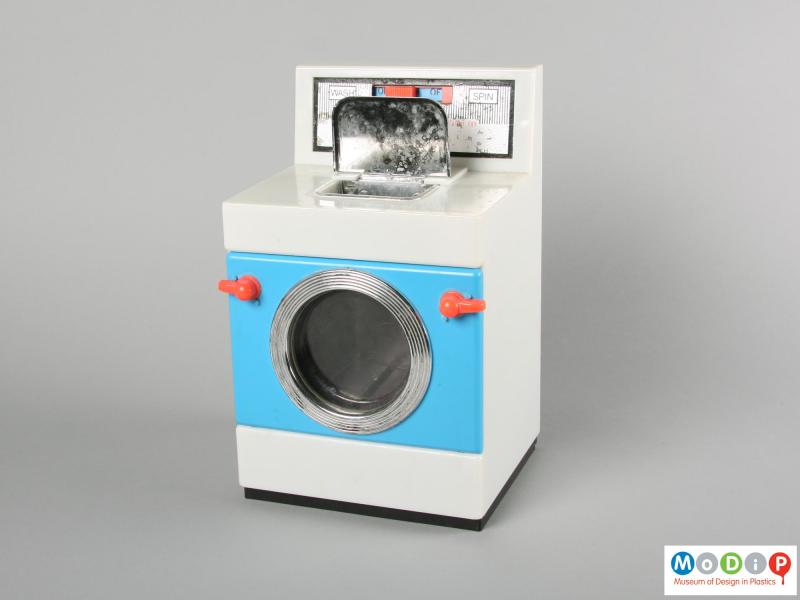 Front view of a Casdon toy washing machine showing the powder compartment cover open and the door clips open.