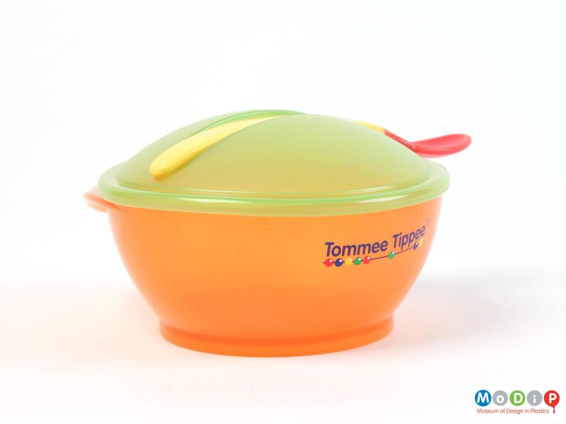 Side view of a Tommee Tippee weaning set showing the lid on the bowl and the spoon in the slot on the lid.