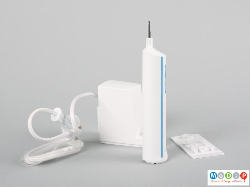 Side view of an electric toothbrush showing the body and charging unit.