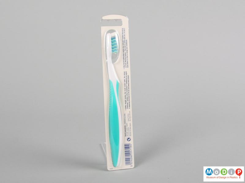 Rear view of a packaged toothbrush showing the back of the packaging.