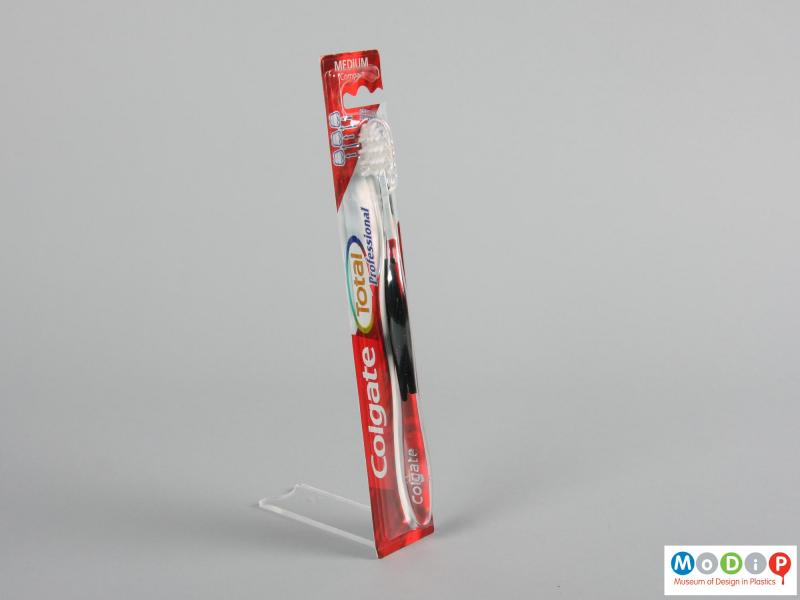 Side view of a packaged toothbrush showing the ergonomic shape of the handle and head.
