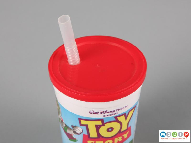 Top view of a Toy Story beaker showing the straw poking through a hole in the lid.