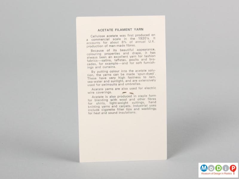 Rear view of a fabric sample card showing the printed information about the material.