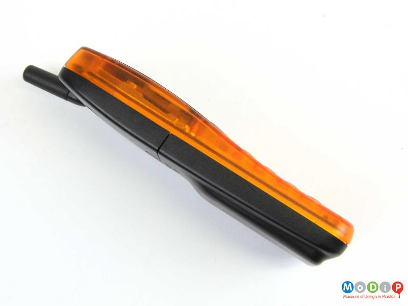 Side view of a mobile phone showing the translucent orange front cover.