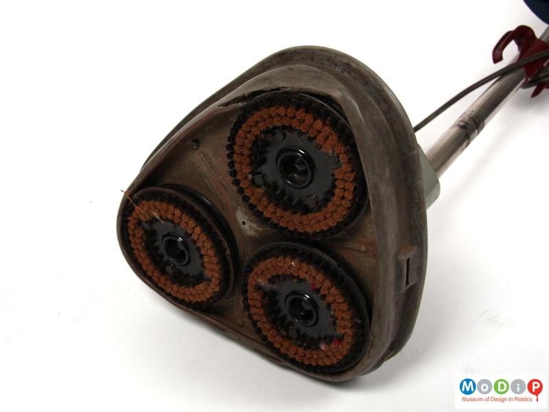 Underside view of an Electrolux floor polisher showing the three circular brushes in the base.