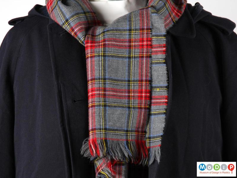 Close view of a scarf showing the tartan pattern.