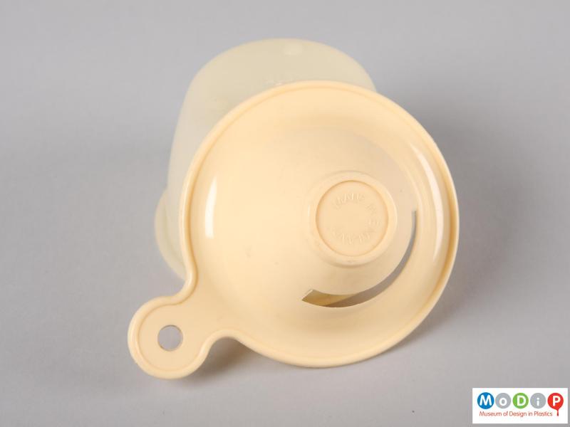 Underside view of an egg separator showing the top section leaning on the base to expose the underside of the top.