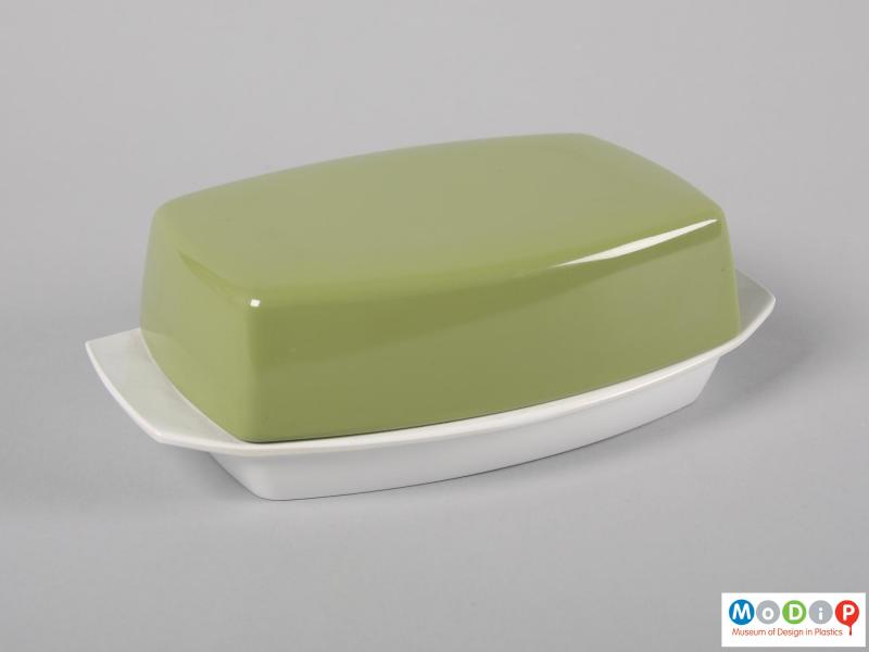 Side view of a butter dish showing the handles on the base.