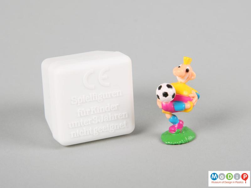 Front view of a football figure showing the football on the foot of the figure and the base of the box.