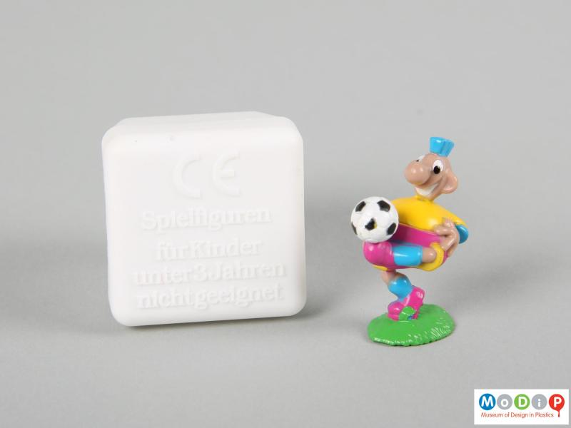 Front view of a football figure showing the football on the foot of the figure and the base of the box.