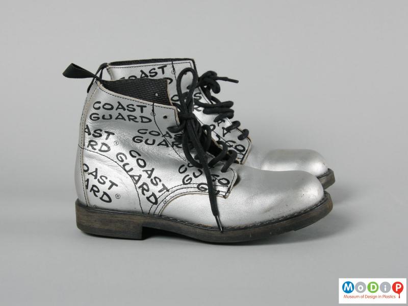 Side view of a pair of boots showing the printed text.