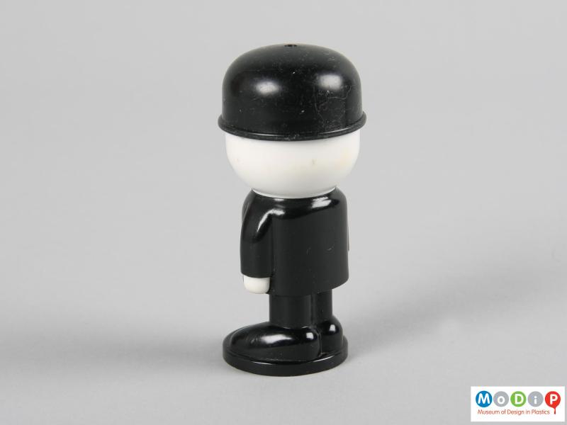 Rear view of a salt shaker showing the white hands and head.