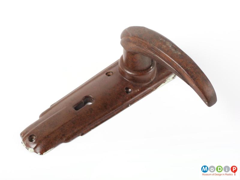 Top view of a door handle showing the escutcheon flat on the surface and the handle to the right of the image.