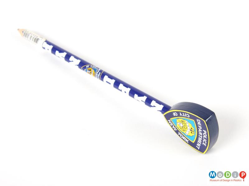 Side view of a New York Police Department pencil showing the depth of the plastic representation of a police badge.