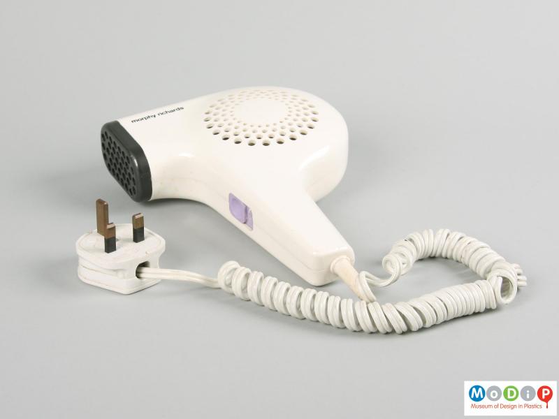 Side view of a hairdryer showing the cable connection and plug.