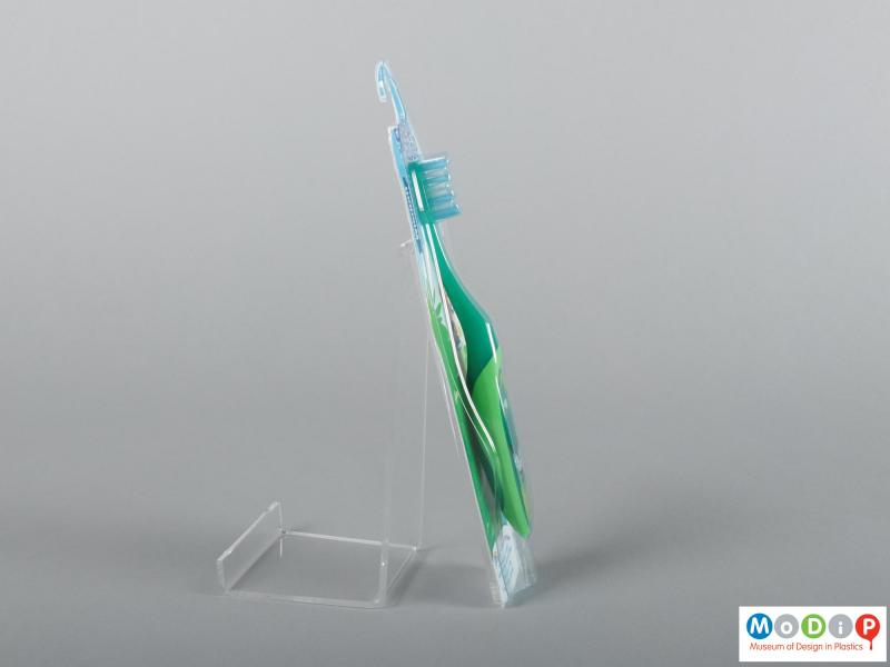 Side view of a pair of packaged toothbrushes showing the handles and bristles.