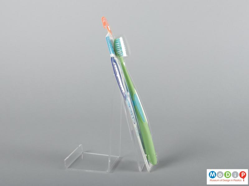 Side view of a pair of packaged toothbrushes showing the handles and bristles.