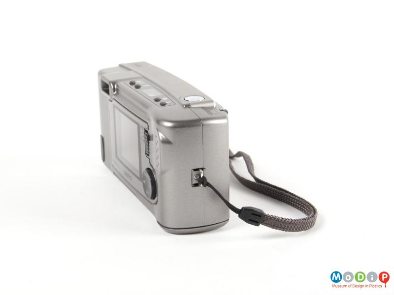 Side view of a digital camera showing the wrist strap and loop attachment.